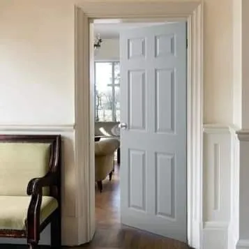 White panelled door opening into a living room